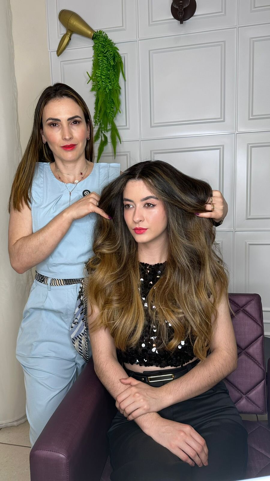 Joelma Lorena mostrando o resultado de mechas balayage uniformes e douradas no cabelo castanho de uma cliente