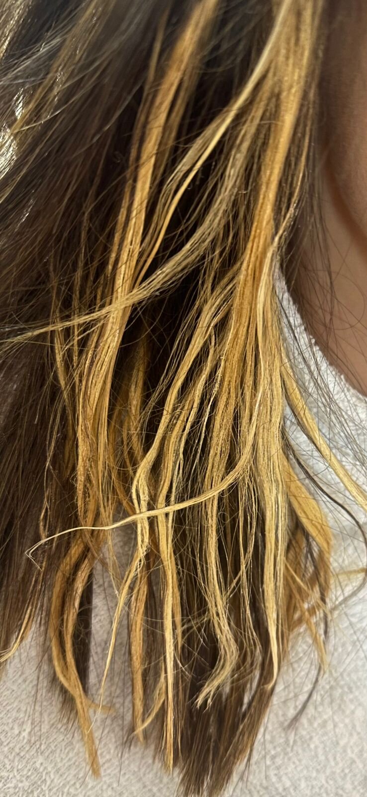 Mechas de cabelo clareadas com fundo alaranjado e amarelo visível, mostrando o ponto do fio antes do diagnóstico do volume de clareamento